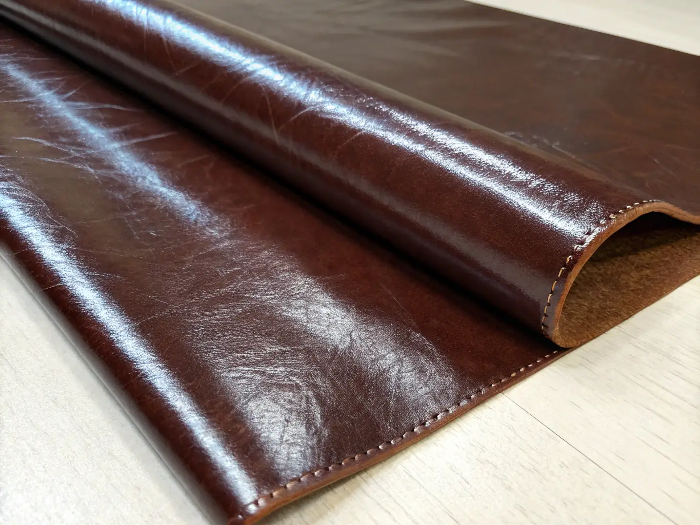 A detailed image showcasing the texture and quality of premium natural leather used in Angelical & Manantial's Summer Collection, highlighting the rich color and supple feel of the material.